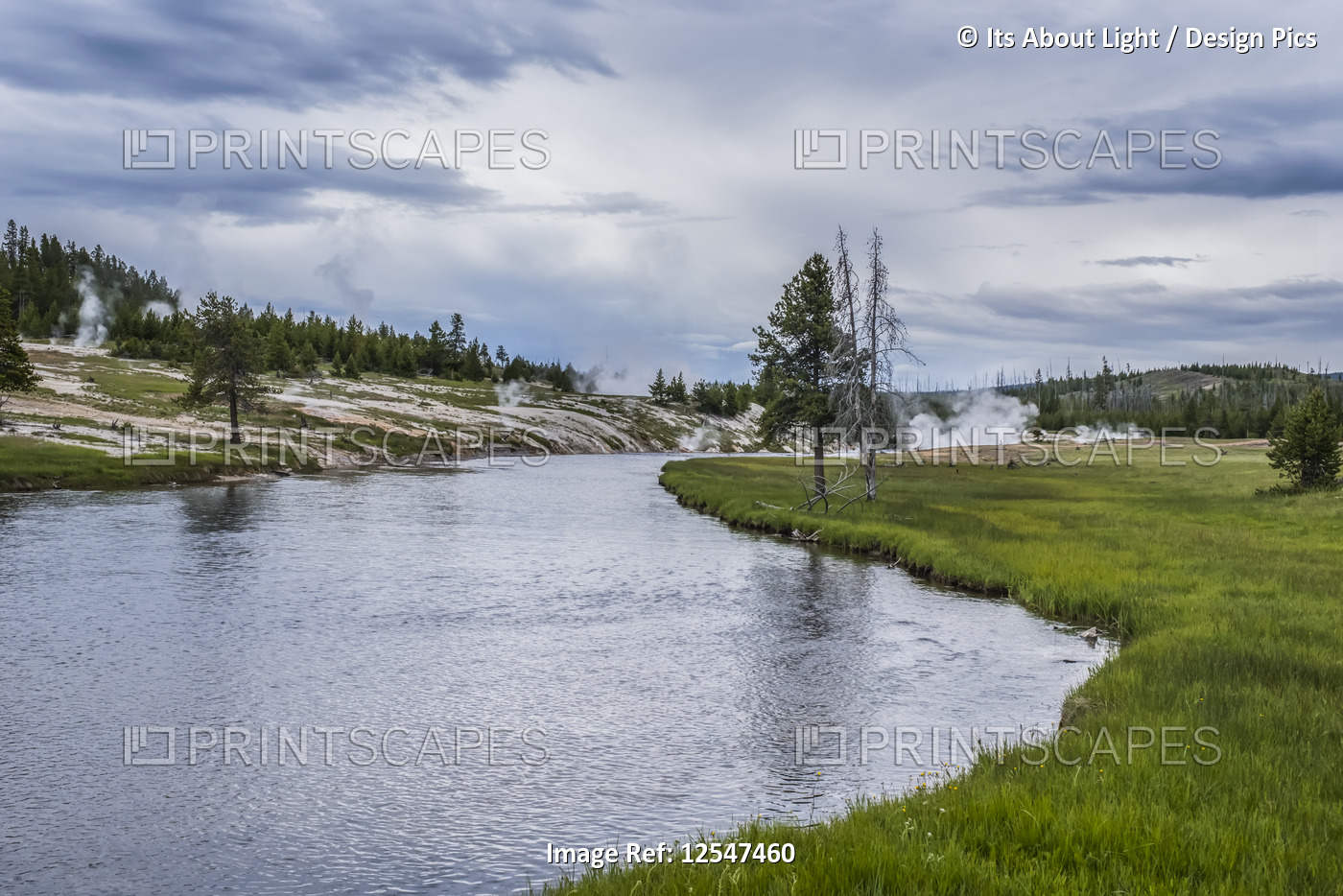 Tranquil river and grass under a cloudy sky, Grand Teton National Park; ...